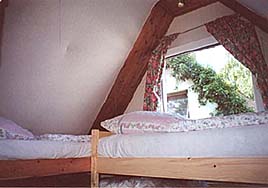 The bedroom area is located under the rooftop, which can be reached by a small staircase