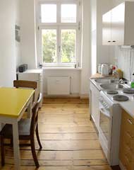 Kitchen with fridge, stove, kettle and dining table
