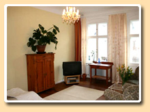 Eine gemütliche Sitzecke, Fernseher - Das Gästezimmer in Berlin Neukölln