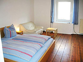 Tweepersoonskamer met een groot tweepersoonsbed en een sofa