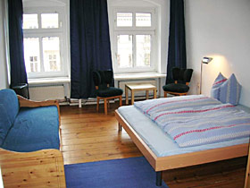 Tweepersoonskamer met een groot tweepersoonsbed, slaapbank en zithoek