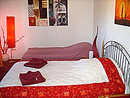 Large double and single bed in a room with a balcony in Munich