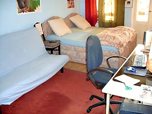 Sofá-cama, escritorio con ordenador y conexión a Internet en la habitación de huéspedes de Berlín
