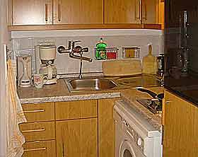 Kitchen with  washing machine in the holiday apartment