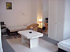 Lit simple et grand coffret de tenue dans la chambre