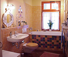 de betegelde badkamer met bad
