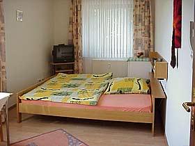 Gästezimmer mit TV und Kühlschrank