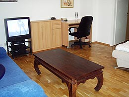 a samll desk and a tv in the sleeping/living room