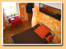 the large double bed and a cosy corner to seat, orange bedroom - guest room near the city in Frankfurter Eastend