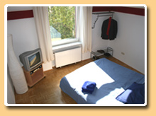 Das große Doppelbett und Fernseher, Red Bedroom - Das Gästezimmer im citynahen Frankfurter Eastend